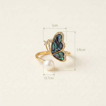 Model wearing the Aura butterfly ring in natural light to show color-shifting shell wings