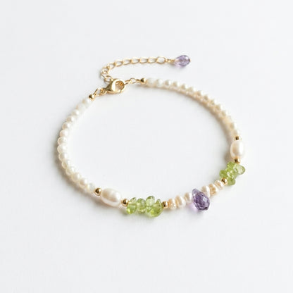 Delicate bracelet with pearls and multicolored beads on a white background