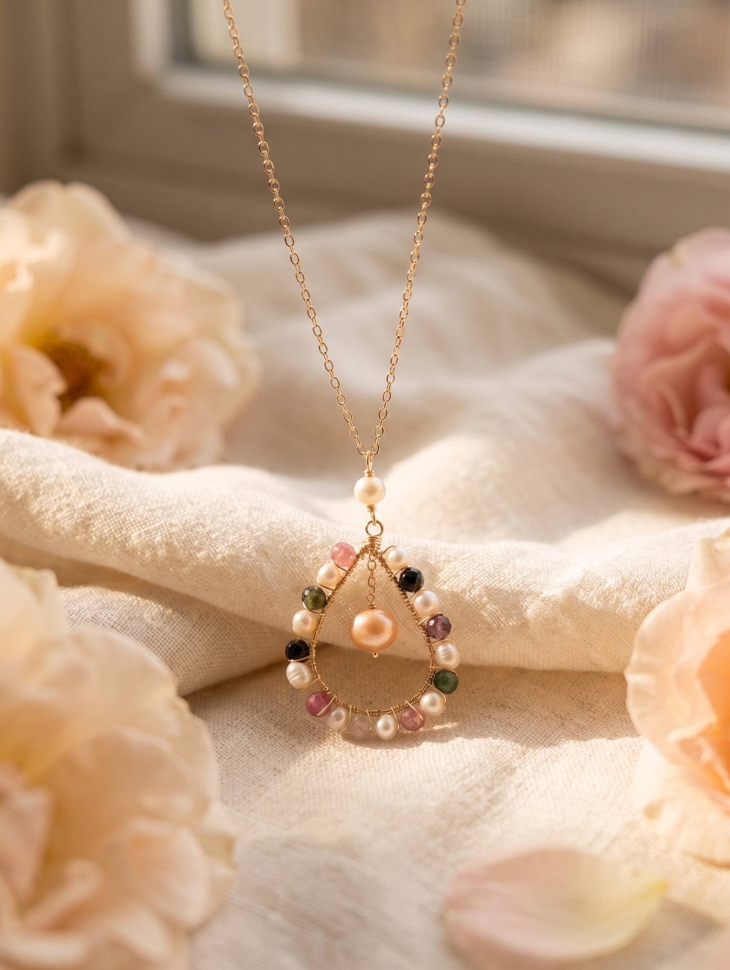 Delicate necklace with beads on a soft fabric background with flowers