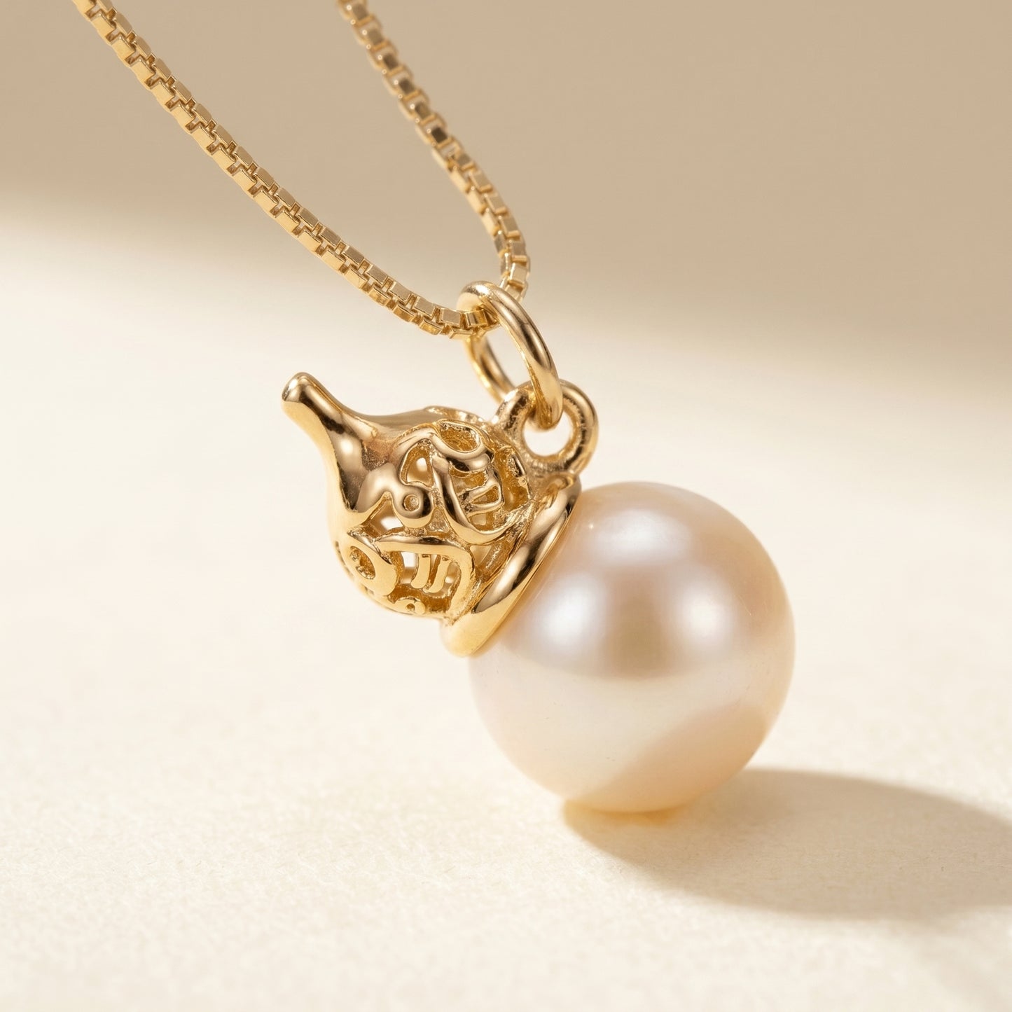 Pearl necklace with gold pendant on a beige background