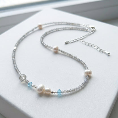Necklace with pearls and blue beads on a white surface