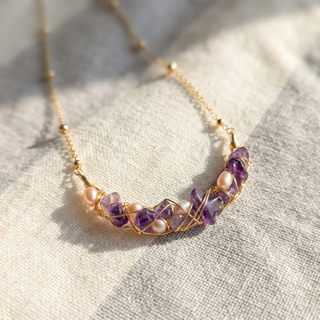 Close-up of a woman wearing a minimalist purple amethyst layering necklace in gold.