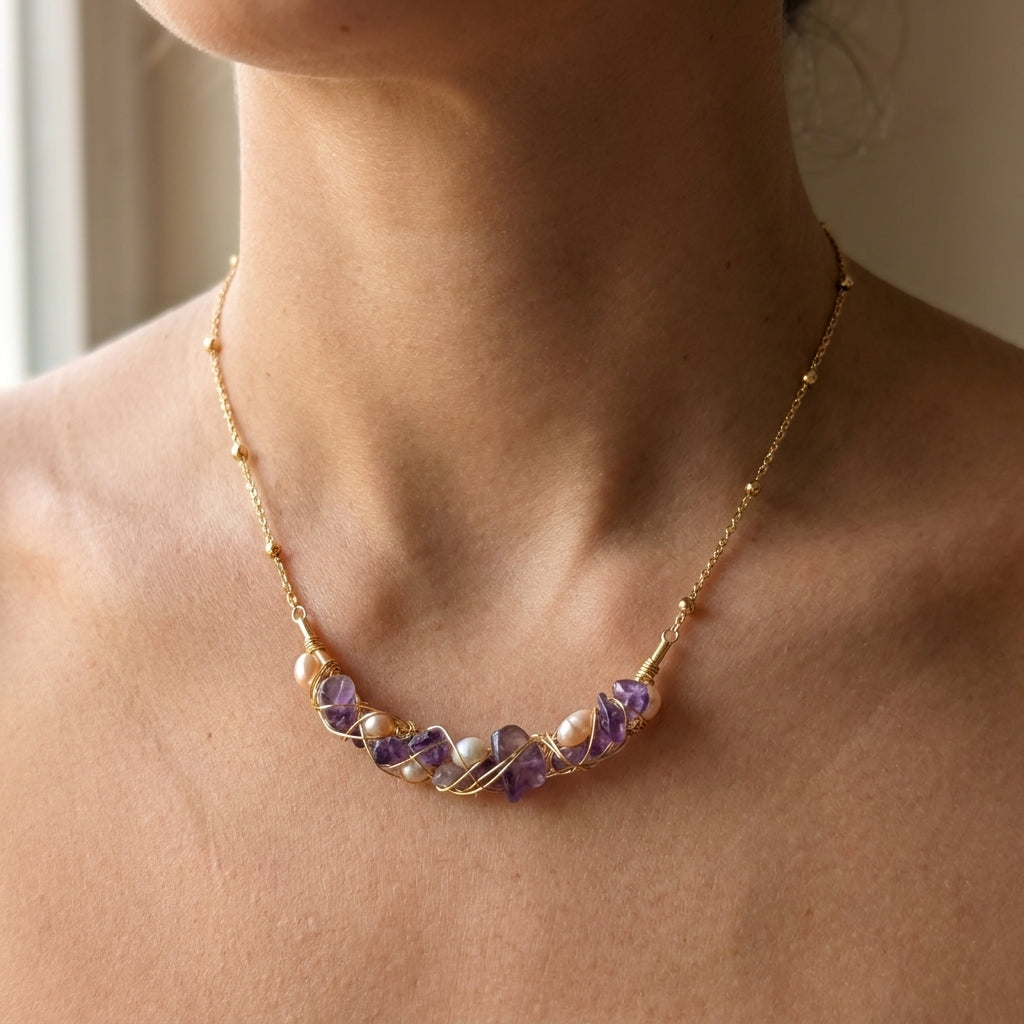 legant everyday jewelry styling featuring a dainty purple gemstone and pearl necklace worn by a model.