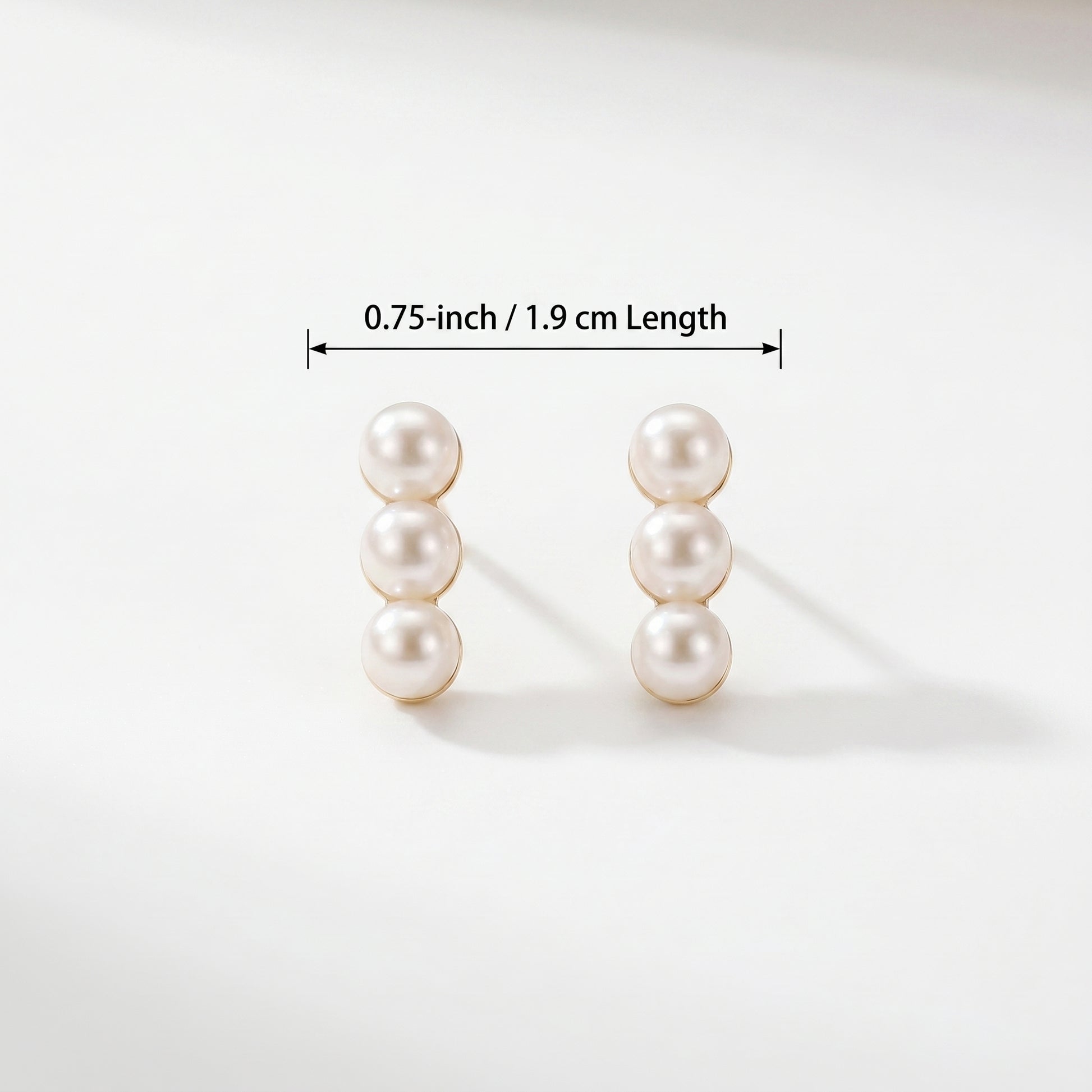 Size guide and dimension diagram for the Lumina Trio three-pearl linear stud earrings.