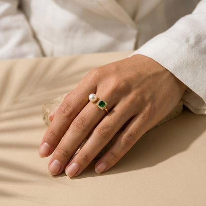 Woman wearing The 'Muse' emerald and pearl open ring styled effortlessly with a classic white shirt cuff.