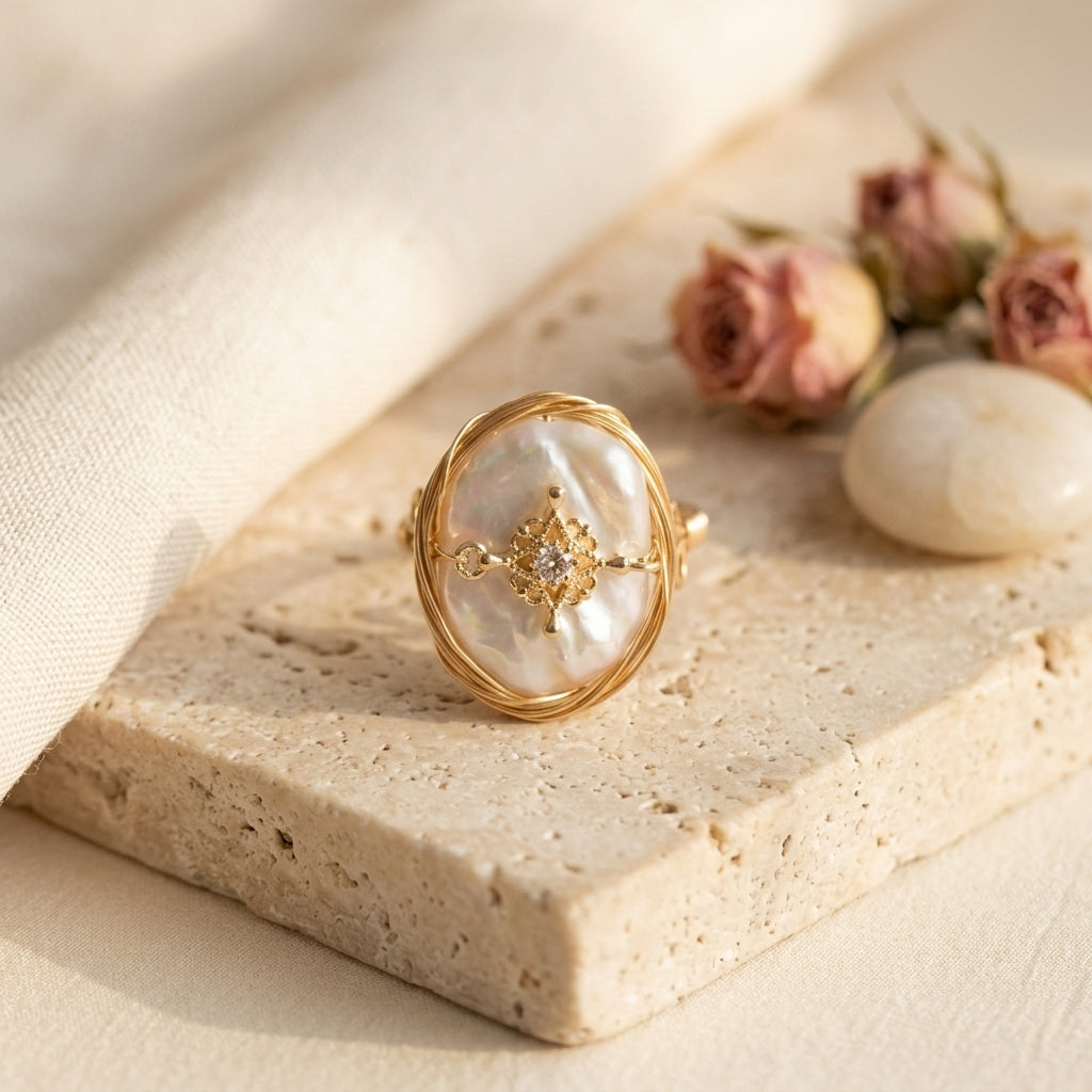 Hand wearing The 'Aurelia' wire wrapped statement pearl ring, displaying the elegant drape of the vintage zircon charm