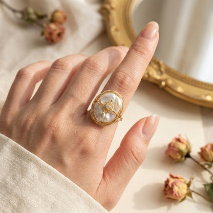 Close-up of The 'Aurelia' handmade wire wrapped baroque pearl ring worn on a finger, showcasing the adjustable band and zircon charm.