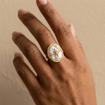Model wearing The 'Aurelia' 14K gold plated baroque pearl ring while holding a string of pearls, capturing a romantic vintage aesthetic.
