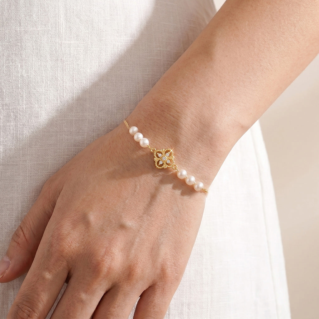 18K gold-plated Aurelia vintage pearl charm bracelet worn on a woman's wrist, designed by Whisperland Studio.