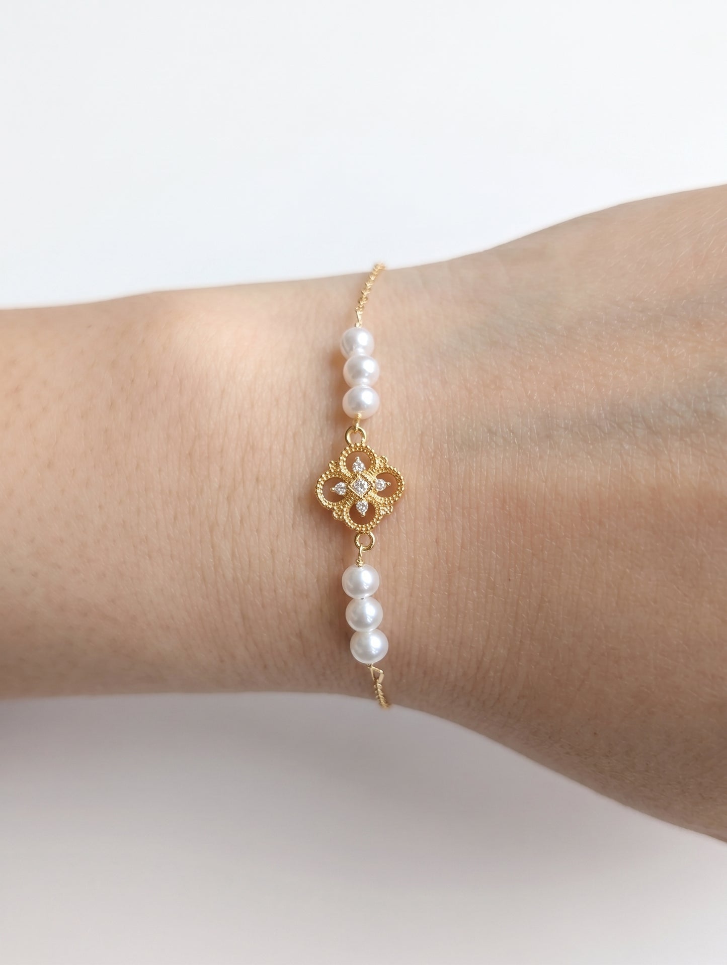 Close-up detail of the natural freshwater pearls and 18K gold chain of the minimalist Aurelia bracelet.