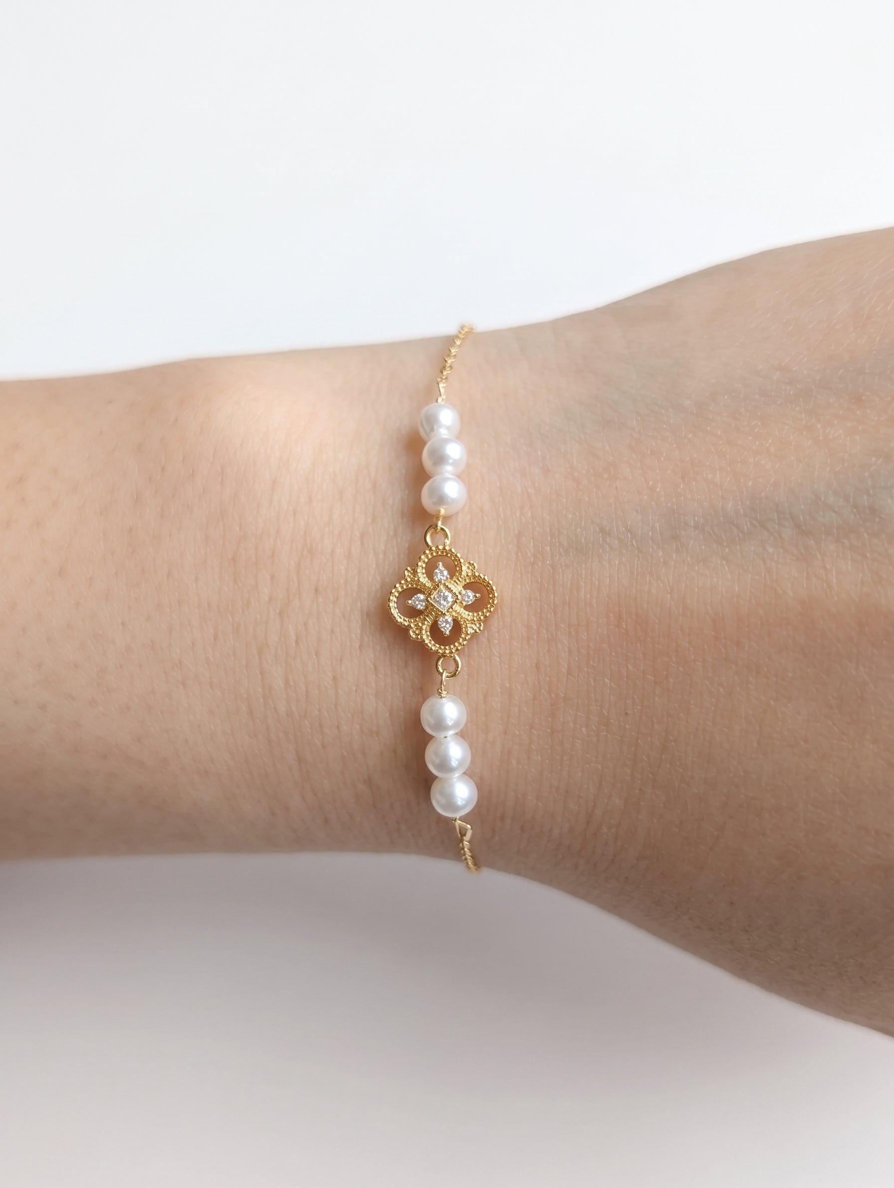 Close-up detail of the natural freshwater pearls and 18K gold chain of the minimalist Aurelia bracelet.