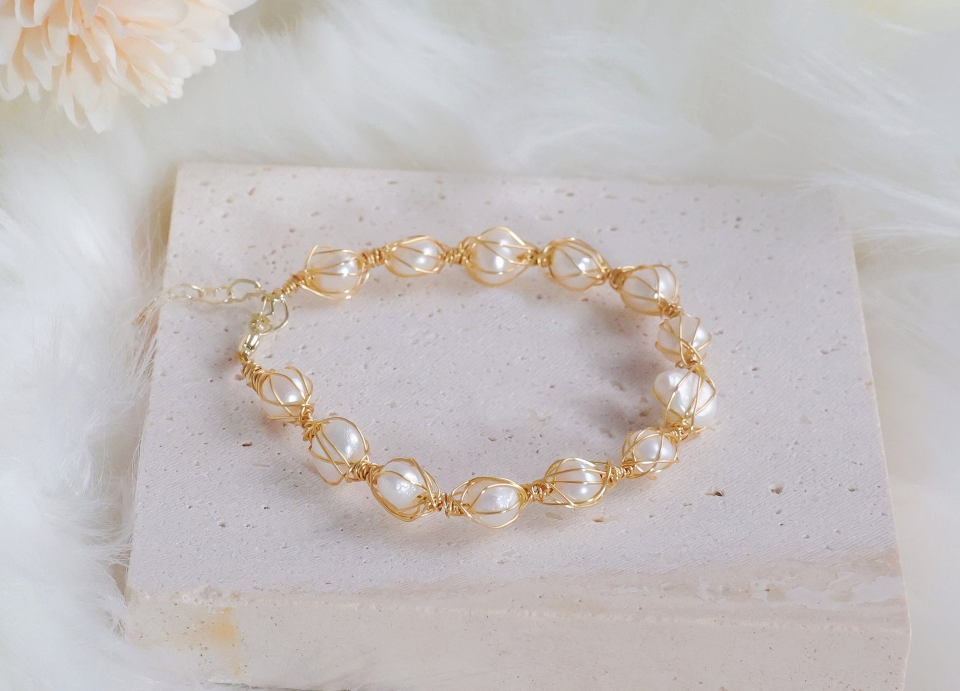 Dainty Seraphina pearl bracelet resting on a decorative surface - Elegant jewelry display