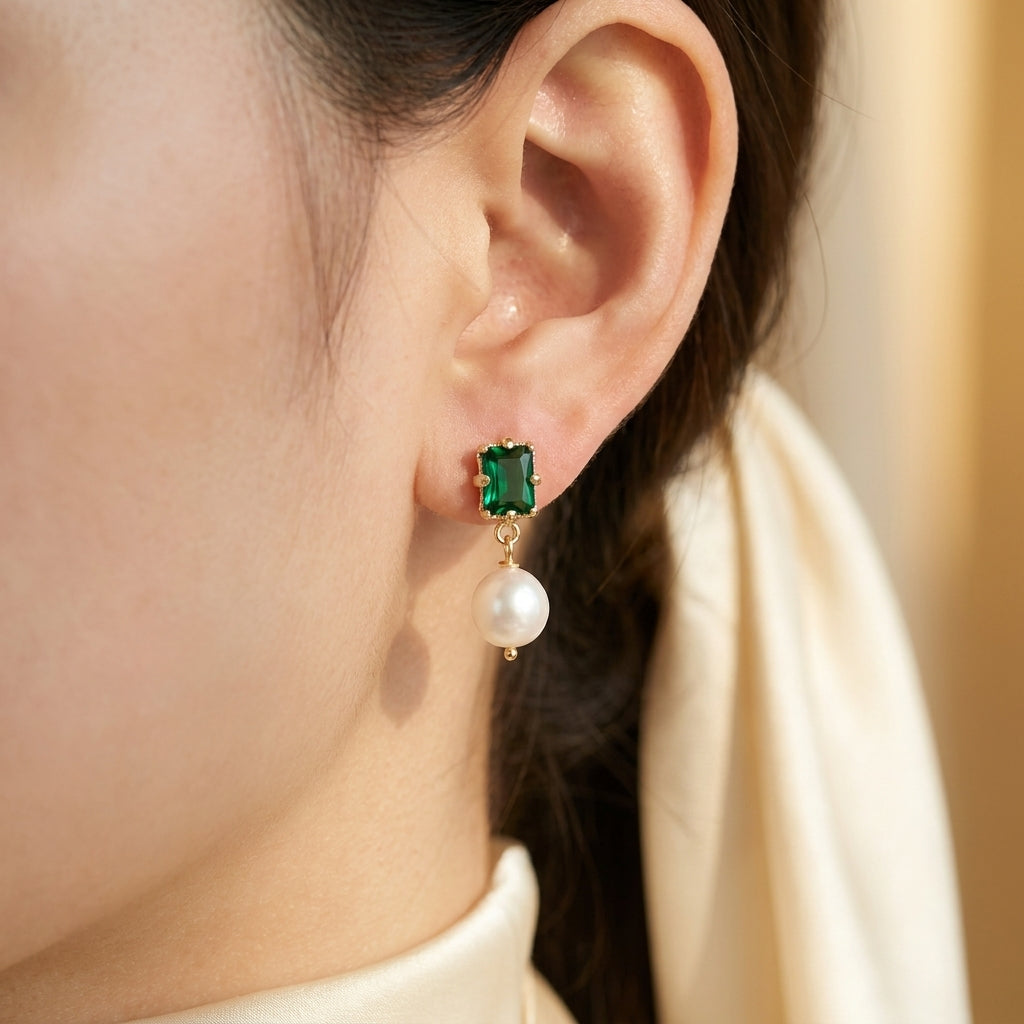 Model wearing the “Eden’s Whisper” Emerald and Freshwater Pearl Drop Earrings in 14K Gold