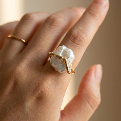 Side profile of The 'Embrace' statement ring on a finger, emphasizing the adjustable 14K gold band and artistic details.