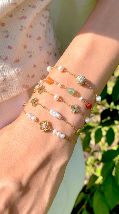 Everyday elegant styling of the 14K gold and freshwater pearl bracelet worn on a wrist with a sheer white sleeve.