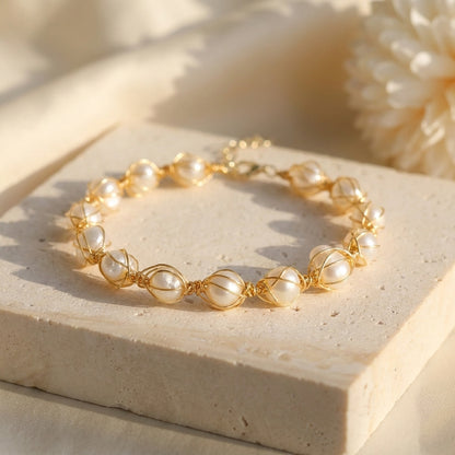 Top-down view of The Handmade Freshwater Pearl Wire Wrapped Gold Bracelet by Whisperland Studio