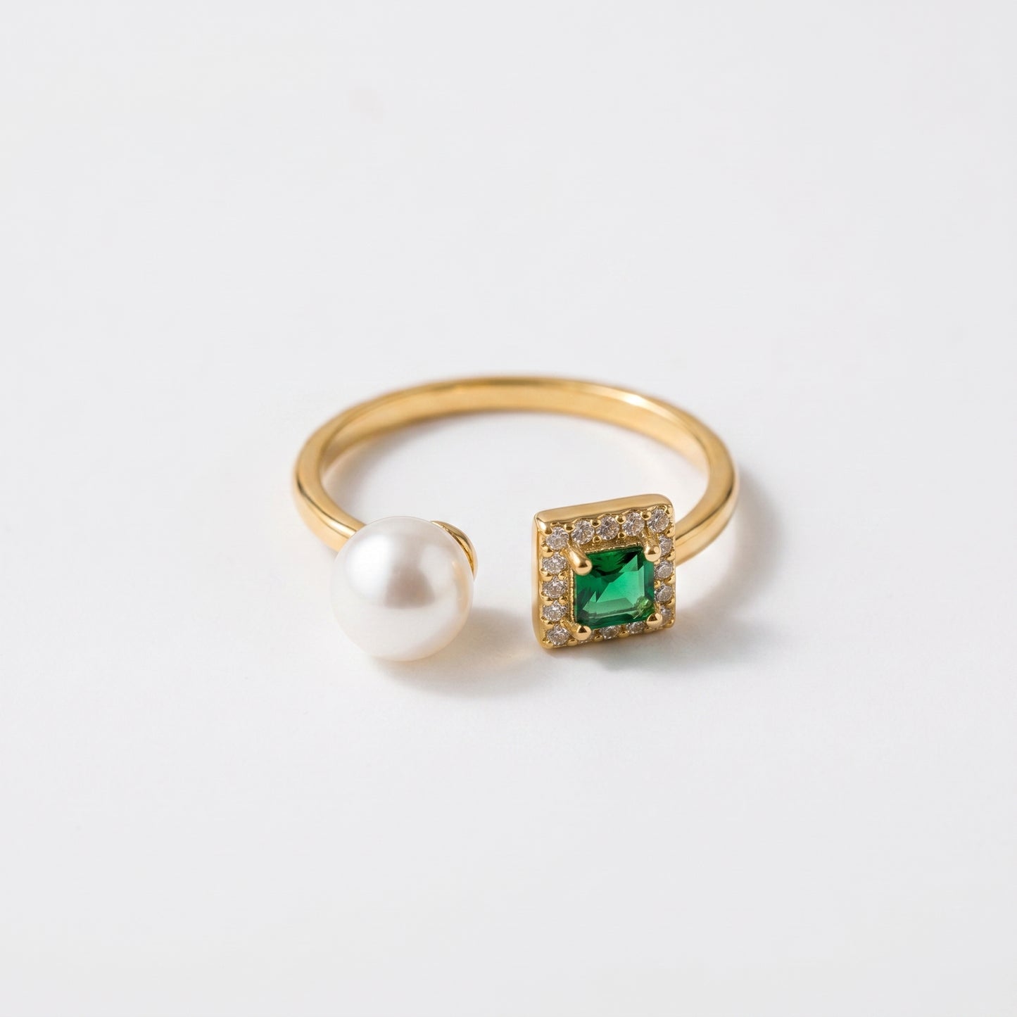 Close up of The 'Muse' 14K gold adjustable ring featuring an emerald-cut stone and three freshwater pearls on a white background.