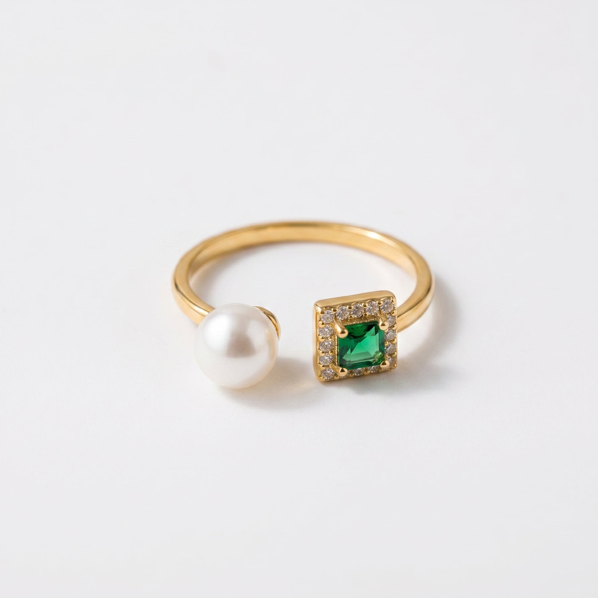 Close up of The 'Muse' 14K gold adjustable ring featuring an emerald-cut stone and three freshwater pearls on a white background.