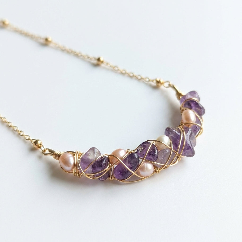 Detailed view of faceted natural purple amethyst stones and genuine freshwater pearls on a gold chain.