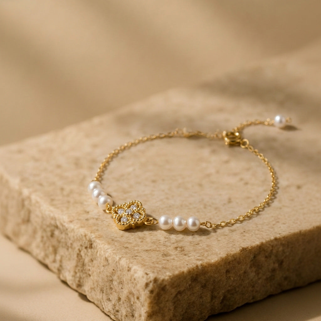 Aurelia natural freshwater pearl and gold bracelet worn outdoors with green foliage in the background, showing everyday styling.