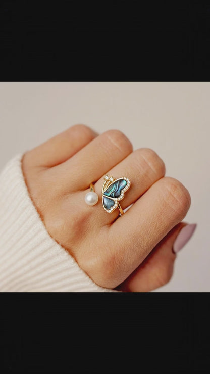 Video showcase of the Aura Abalone Butterfly Ring, showing the dynamic iridescent glow of the shell wings and the luster of the freshwater pearl on a hand by Whisperland Studio