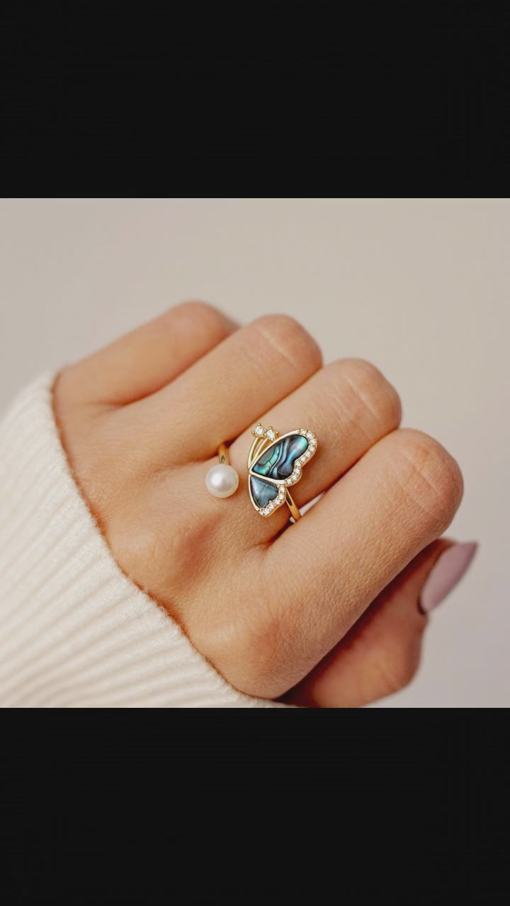 Video showcase of the Aura Abalone Butterfly Ring, showing the dynamic iridescent glow of the shell wings and the luster of the freshwater pearl on a hand by Whisperland Studio