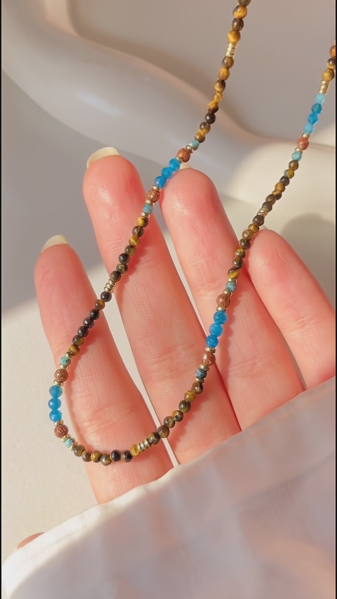 Video showcasing the light handmade details and natural shimmer of the Terra Aura gemstone necklace.