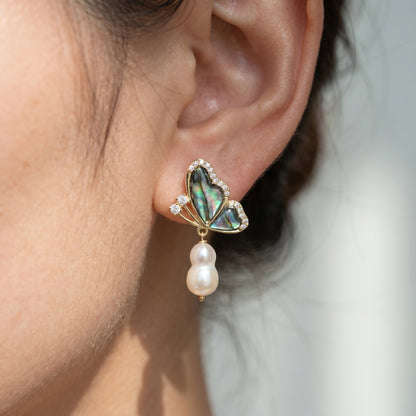 Woman wearing romantic abalone butterfly and baroque pearl earrings, perfect for everyday wear or bridal styling