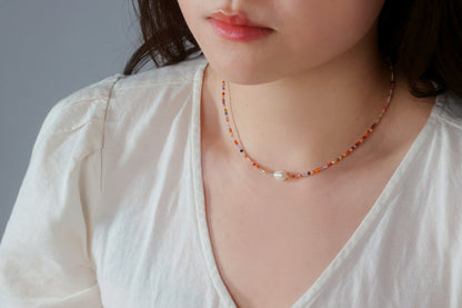 Model wearing the Sunrise Whisper dainty colorful beaded necklace with a white top, showcasing it as a versatile everyday accessory by Whisperland Studio.