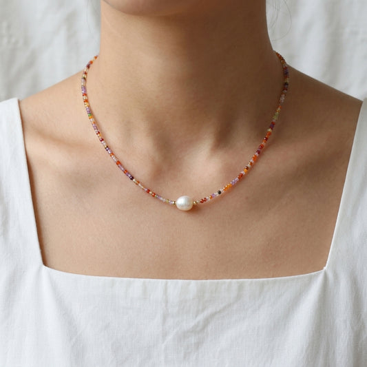 Model wearing the Sunrise Whisper dainty colorful beaded necklace with a central freshwater pearl by Whisperland Studio.