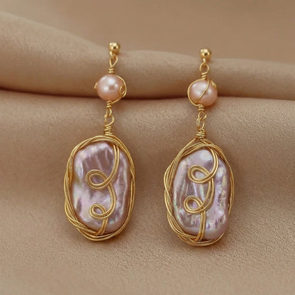 Handmade baroque pearl statement earrings elegantly displayed on a minimalist prop by Whisperland Studio.
