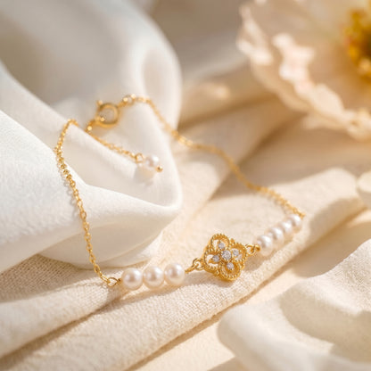 Macro shot of the vintage-inspired diamond-shaped centerpiece charm on the Aurelia 18K gold pearl bracelet.